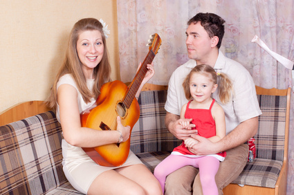 a family, the mother playing guitar