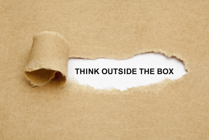 a tear in a paper reveals the words 'think outside the box'