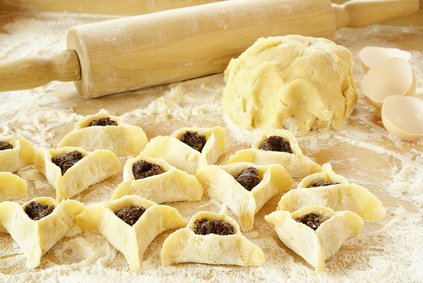 a kitchen table with flour and hamentashen