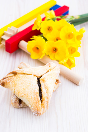 a table with hamentashen, noisemakers and flowers