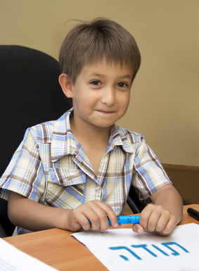 a boy with a hand-written paper that says Thank You