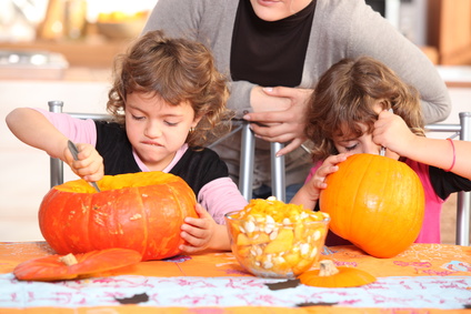 two kids carving pumpkins