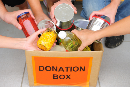 hands dropping products at a donation box