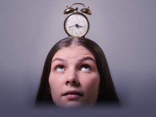 a girl with an alarm clock over her head